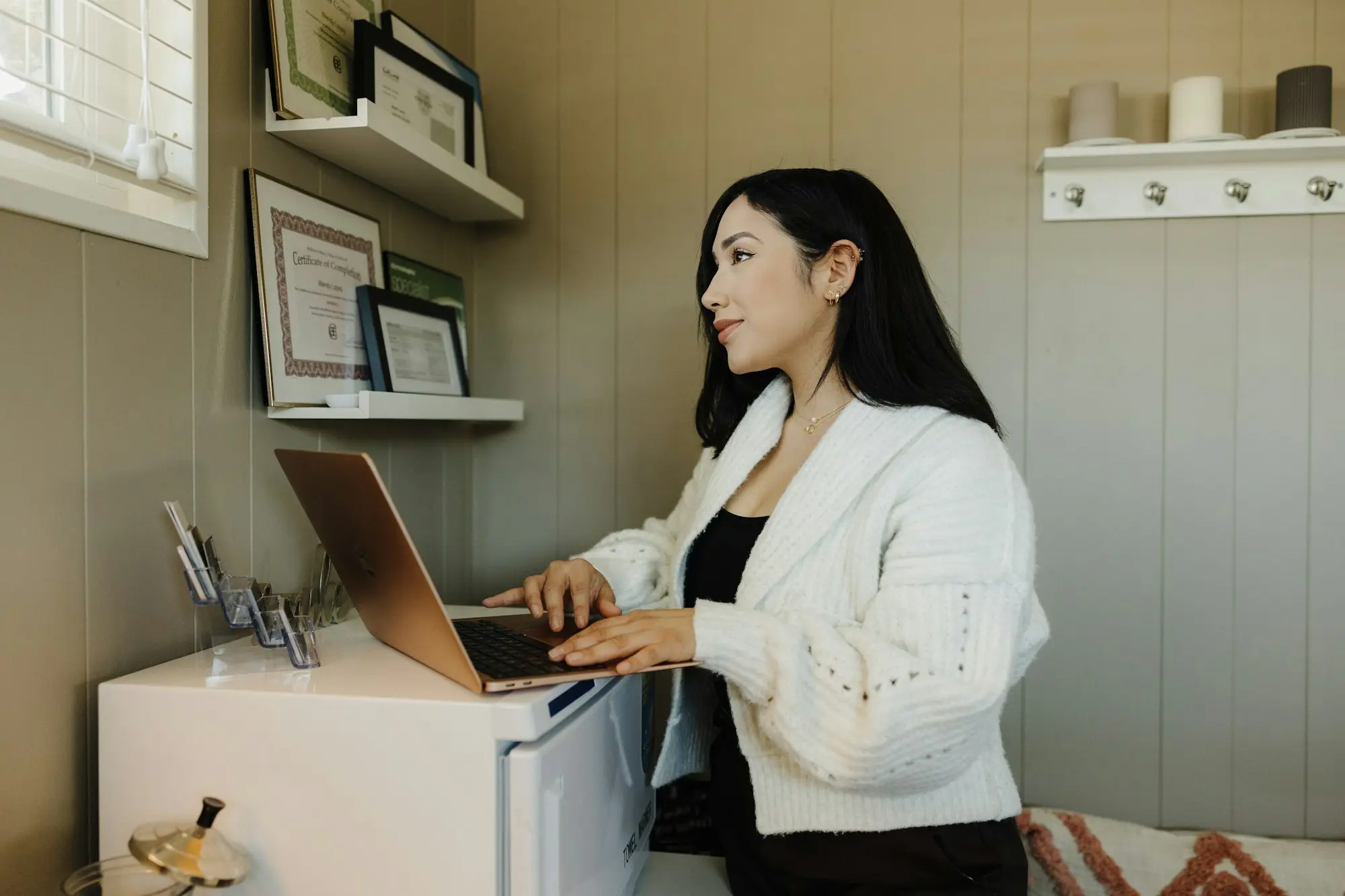 Bookkeeper working on a laptop at a standing desk in a home office