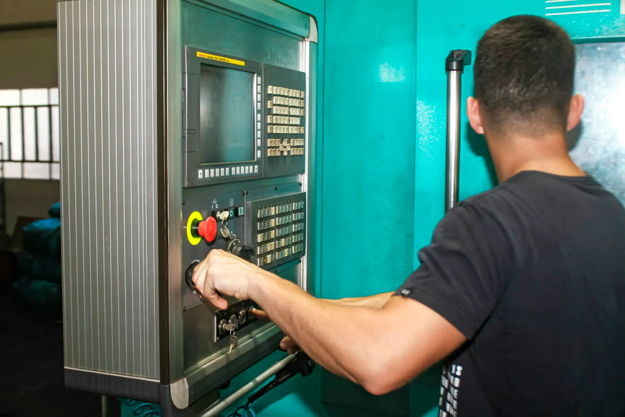 Machinist operating a CNC machine in an engineering workshop