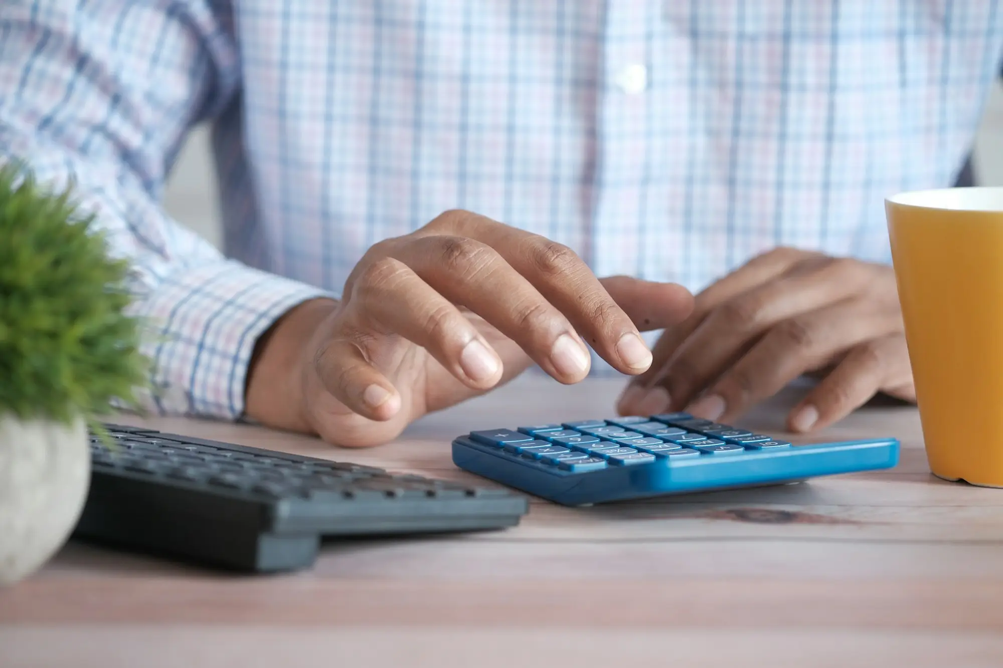 Business owner working out return on investment with a calculator and laptop