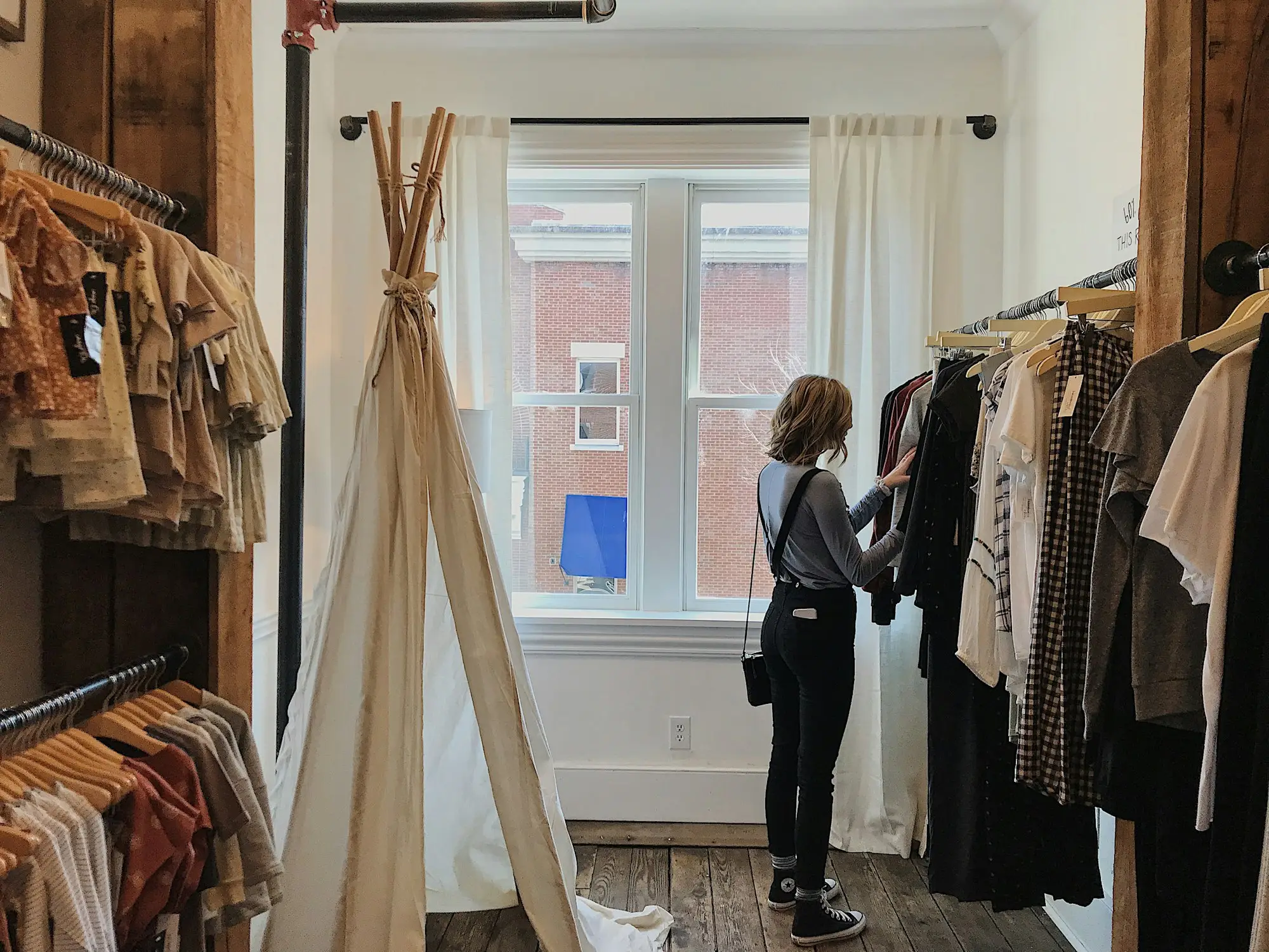 Owner browsing clothing racks in a newly opened boutique