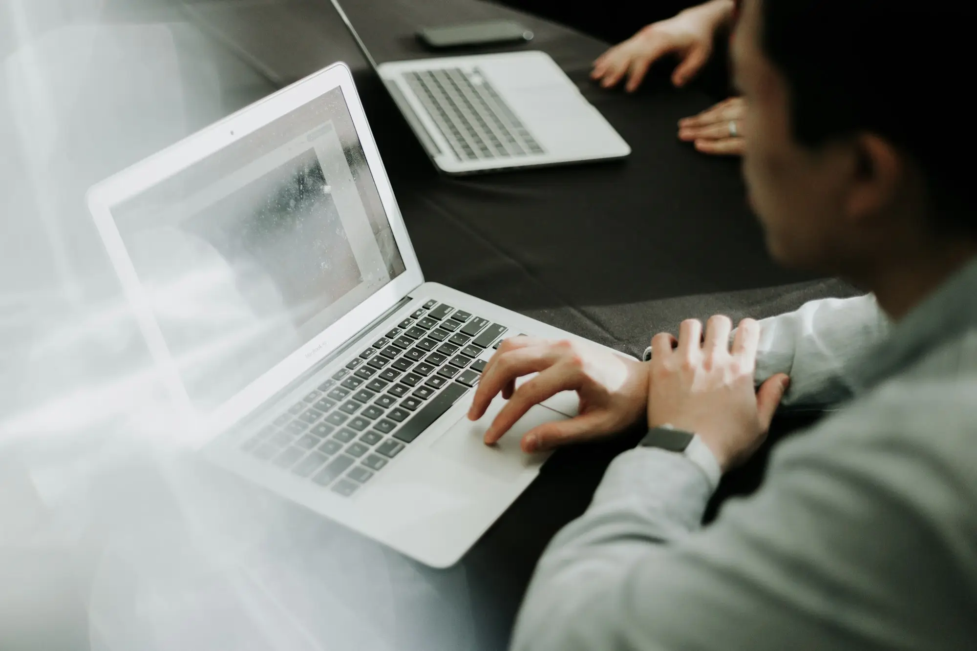 Preparing tender documents on a laptop at an office desk